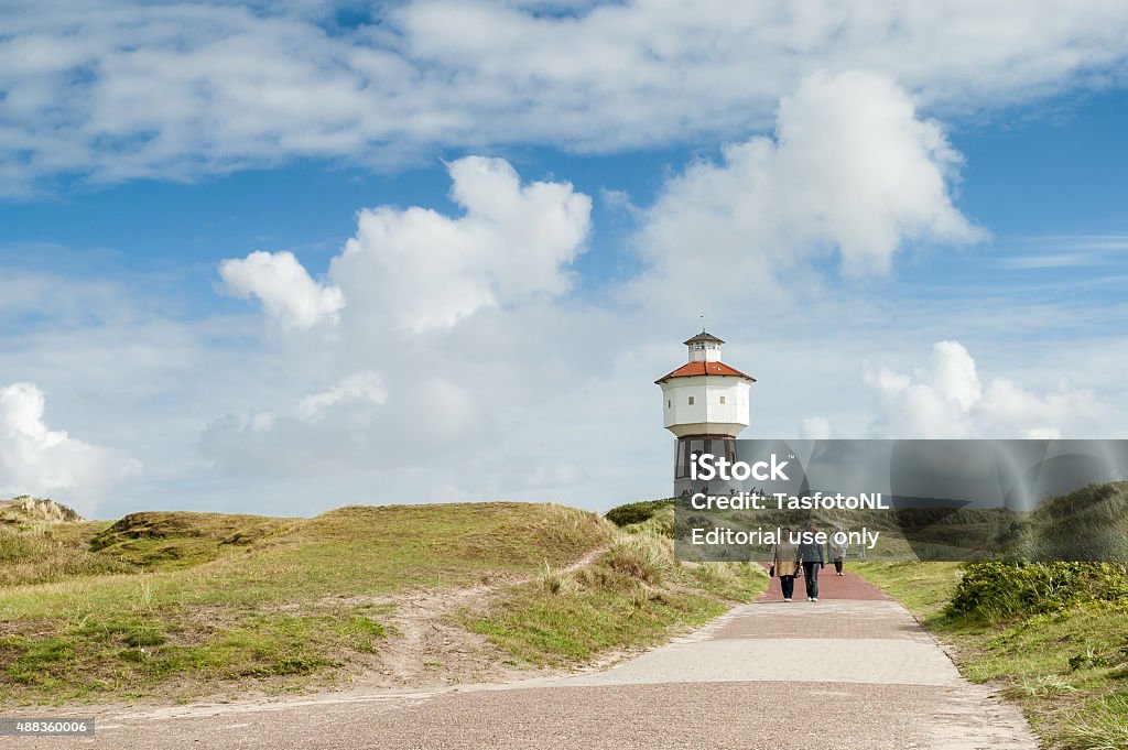 Leisure and water tower on Langeoog, Germany Langeoog Island, Germany - August 31, 2004: People walking in dunes and water tower of East Frisian island Langeoog in Lower Saxony Langeoog Stock Photo