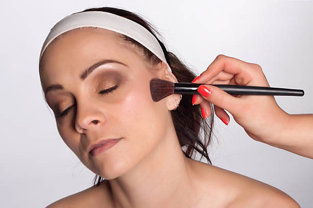 Applying makeup to the face stock photo