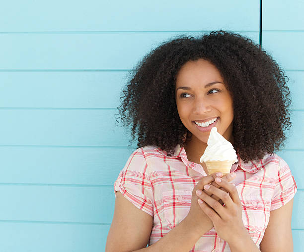 istock Young woman smiling and eating ice cream 488363209