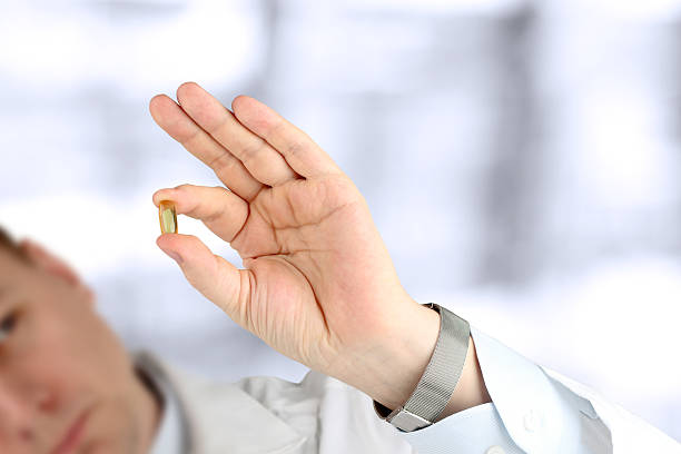 istock Doctor in a white  labcoat looking at  pills 488363566