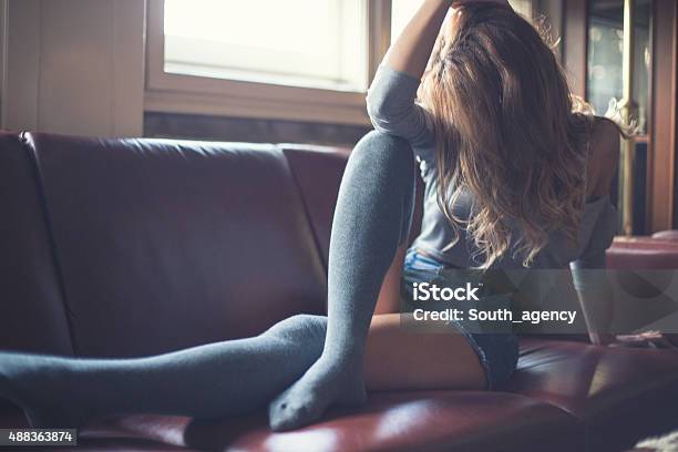 Beautiful Girl Sitting On A Bed Feeling Sad Stock Photo - Download Image Now - Human Sexual Behavior, 2015, 25-29 Years