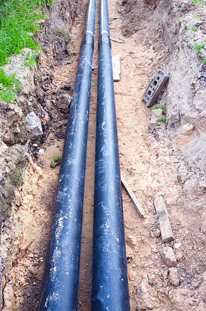 Two new black waterpipes in a ditch