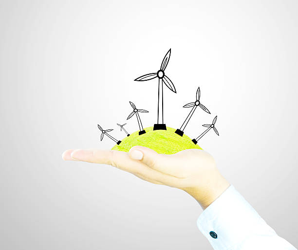 istock wind generator on green wolrd nature by hand 488365705