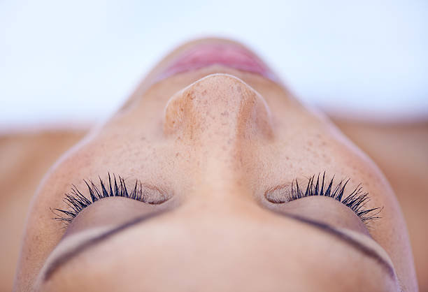 She's in a deeply relaxed state of mind Cropped shot of an attractive young woman lying on her back human nose stock pictures, royalty-free photos & images