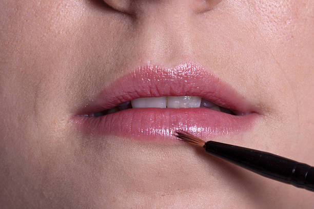 Woman paints lips stock photo