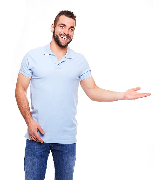 Happy young man in polo shirt showing empty copyspace