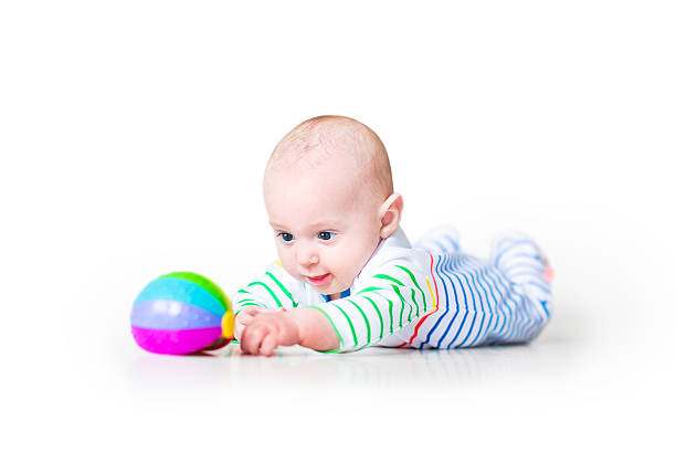 Funny laughing baby boy learning to crawl playing on tummy
