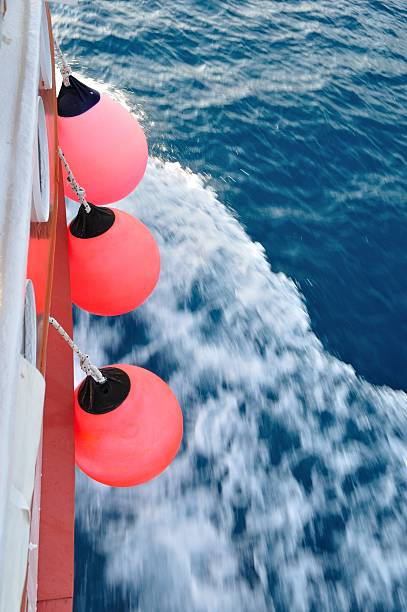istock Red buoy on body of moving ship 488367975