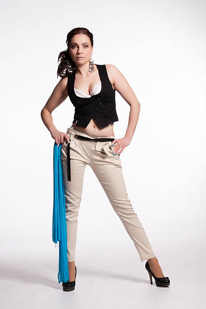 Young woman in beige pants, black vest with blue scarf stock photo