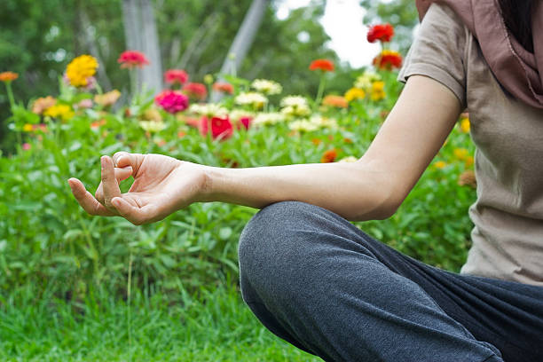 women meditating outdoors in flower park background