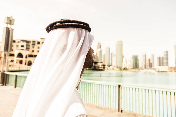 istock Sheikh looking to Dubai downtown skyscrapers and office buildings 488378640