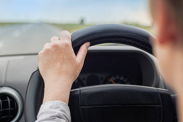istock Woman driving car, hand on steering wheel 488379562