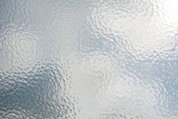 old frosted Glass View of cloudy sky through old frosted patterned glass. glass material stock pictures, royalty-free photos & images