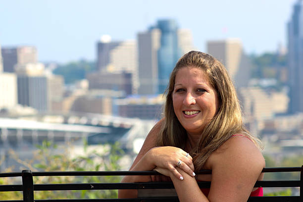 istock Woman on Park Bench Smiles Against Cincinnati Skyline 488385404