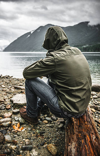 Solitude man pensive on the lake side Solitude man pensive on the lake side spirituality adventure searching tranquil scene stock pictures, royalty-free photos & images