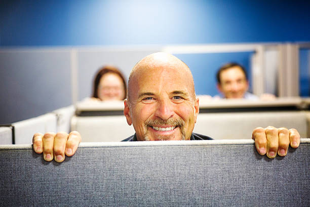 istock Cheerful cubicle worker portrait peeking over wall smiling 488387698