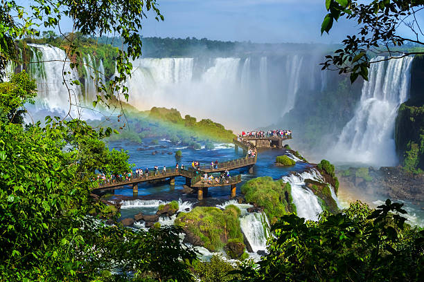 Tourists at Iguazu Falls, Foz do Iguacu, Brazil Tourists at Iguazu Falls, one of the world's great natural wonders, near the border of Argentina and Brazil. natural landmark photos stock pictures, royalty-free photos & images