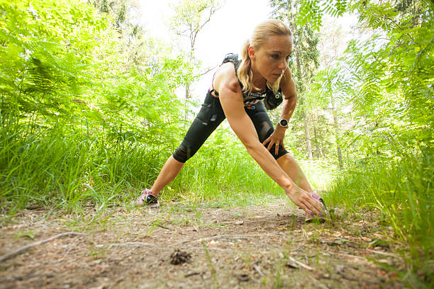 istock Woman exercising on forest trail 488389718