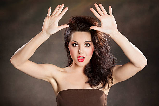 istock Girl with raised hands looking surprised 488391299