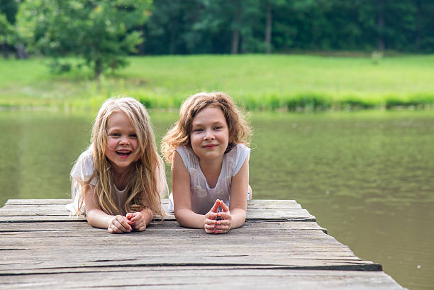 istock Two sisters lying together in the afternoon on the bridge 488392084