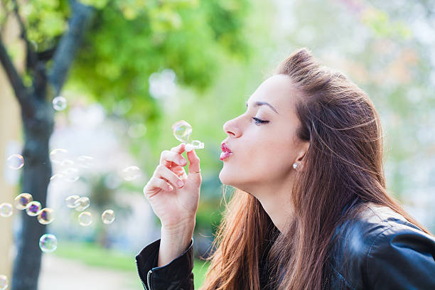 istock Beautiful Woman Blowing Bubbles 488394171