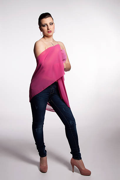 Young woman in pink corset, jeans, high heels with scarf stock photo