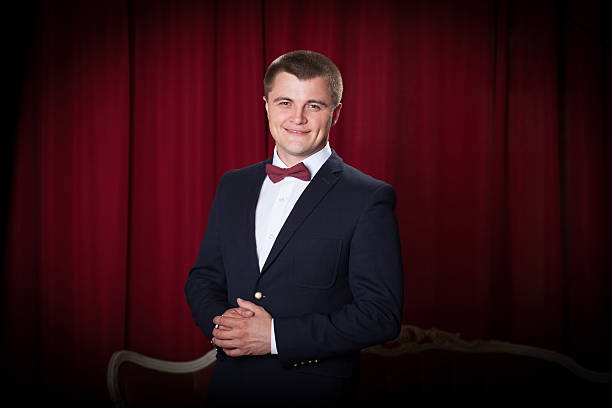 Happy young man in jacket and bowtie expressing positivity