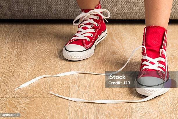 Photo libre de droit de Petite Fille Portant Une Paire De Baskets Rouges banque d'images et plus d'images libres de droit de Défait - Défait, Chaussures, Enfant