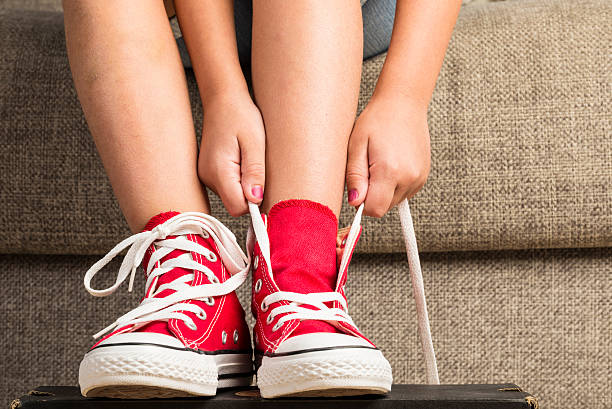 Girl wearing a pair of red sneakers stock photo