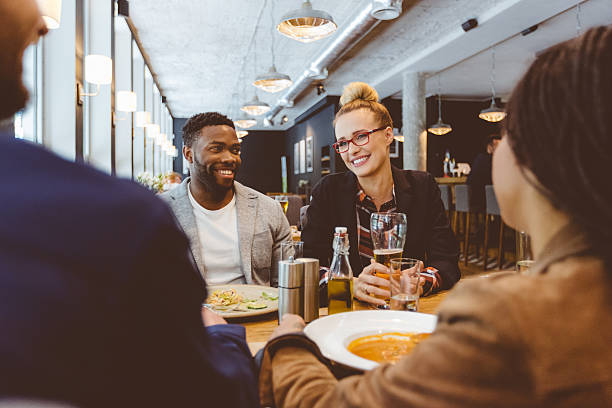 istock Multi ethnic group of friends eating dinner in a restaurant 488405790