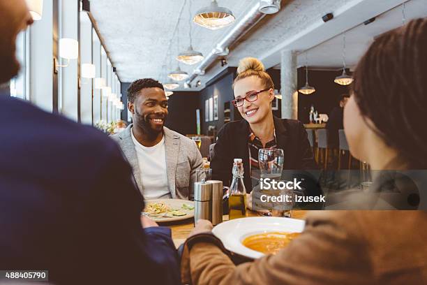 Multi Ethnic Group Of Friends Eating Dinner In A Restaurant Stock Photo - Download Image Now