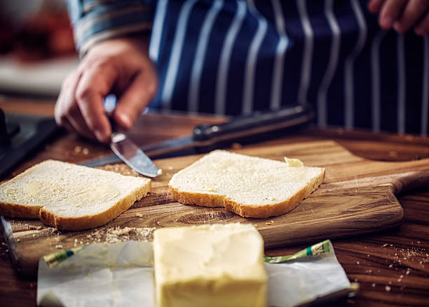 istock Spreading Butter onto Bread for Preparing a Sanwich 488406080