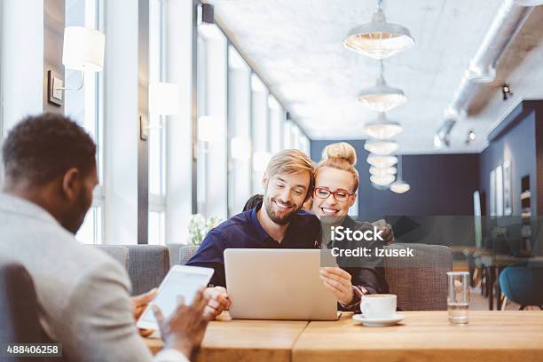 Happy Couple Using Laptop Together In The Restaurant Stock Photo - Download Image Now