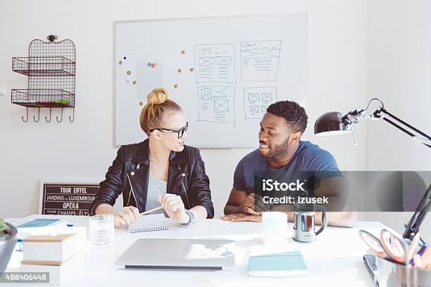 Blonde Woman Talking With Afro American Colleague In Office Stock Photo - Download Image Now