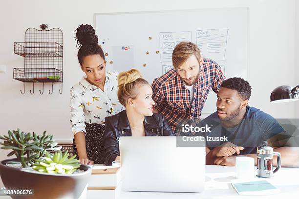 Startup Agency Multi Ethnic Team Brainstorming Using Laptop Stock Photo - Download Image Now