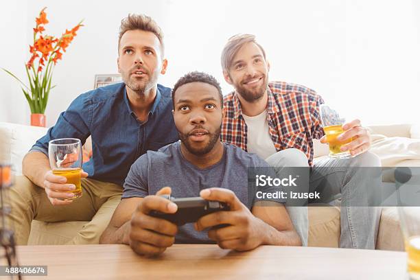 Three Guys Playing Video Games Stock Photo - Download Image Now - Video Game, African Ethnicity, African-American Ethnicity