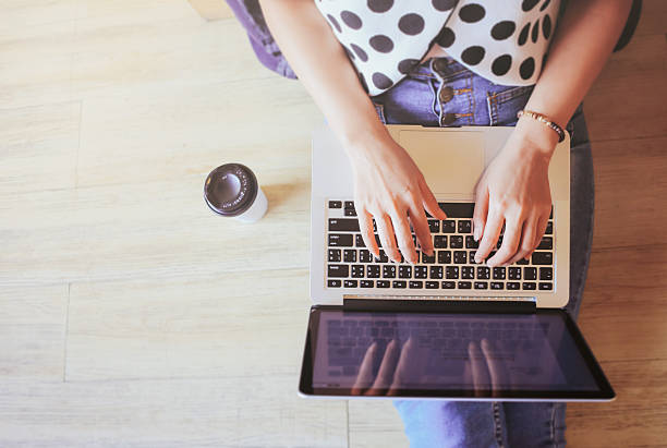 istock Top view of laptop in girl's hands sitting on floor 488407708