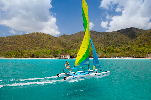young woman in bikini sailing on a catamaran in Cinnamon Bay, St.John, US Virgin Islands