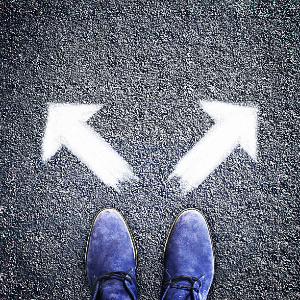 istock Men's shoes and two arrows in different directions 488413268