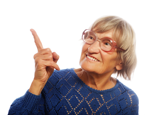 happy senior woman pointing upwards isolated on white background