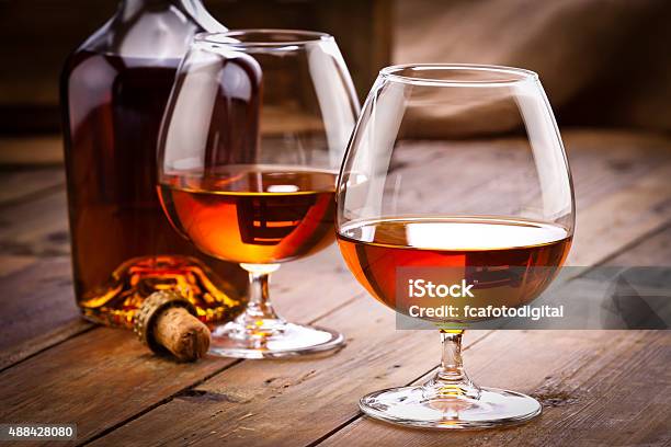 Cognac Snifters With Bottle On Rustic Wood Table Stock Photo - Download Image Now - Cognac - Brandy, Brandy, Drinking Glass