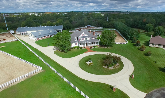 Country ranch, mansion with horse barns and pens.