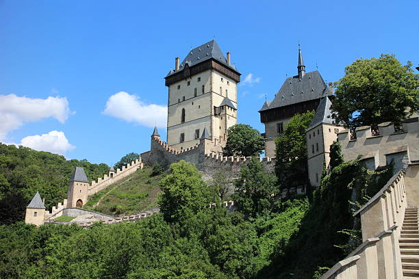 Karlstein, Сzech Republic - August 12, 2014: Karlštejn Castle is a large Gothic castle founded 1348 AD by Charles IV, Holy Roman Emperor-elect and King of Bohemia. The castle served as a place for safekeeping the Imperial Regalia as well as the Bohemian/Czech crown jewels, holy relics, and other royal treasures. Located about 30 km southwest of Prague above the village of the same name, it is one of the most famous and most frequently visited castles in the Czech Republic.