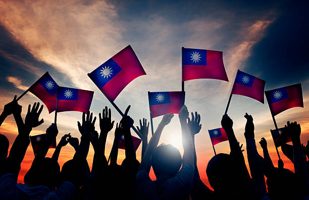 istock Group of People Waving Taiwanese Flags in Back Lit 488433726