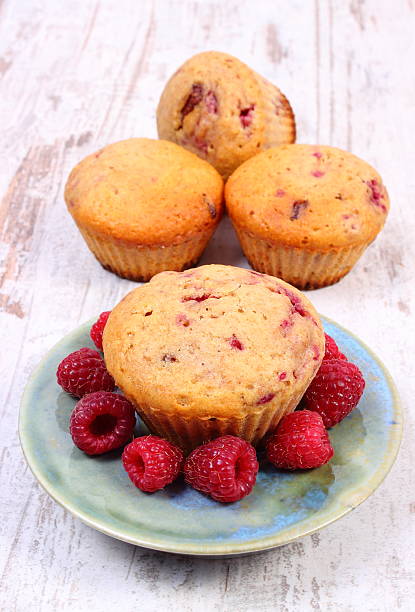 istock Fresh baked muffins with raspberries on wooden background 488436232
