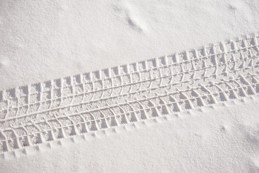 Sedan car tire track in fresh snow