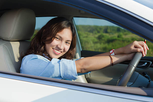 istock female driving happy about her new car or drivers license 488439452
