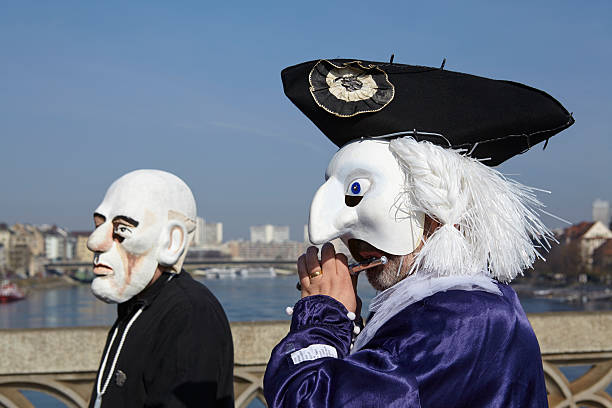 Basel (Switzerland) - Carnival 2014 Basel, Switzerland - March 10, 2014: Two unidentified costumed persons go across the middle rhine bridge and make music before the carnival procession starts. They are participants at Basel fasnacht on March 10, 2014. fastnacht stock pictures, royalty-free photos & images