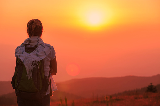 Hiking. Rear view  women hiker, enjoying in the great view. Sunset, alpine mountain landscape.