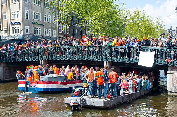 Boat party through Amsterdam canals during King's Day. stock photo